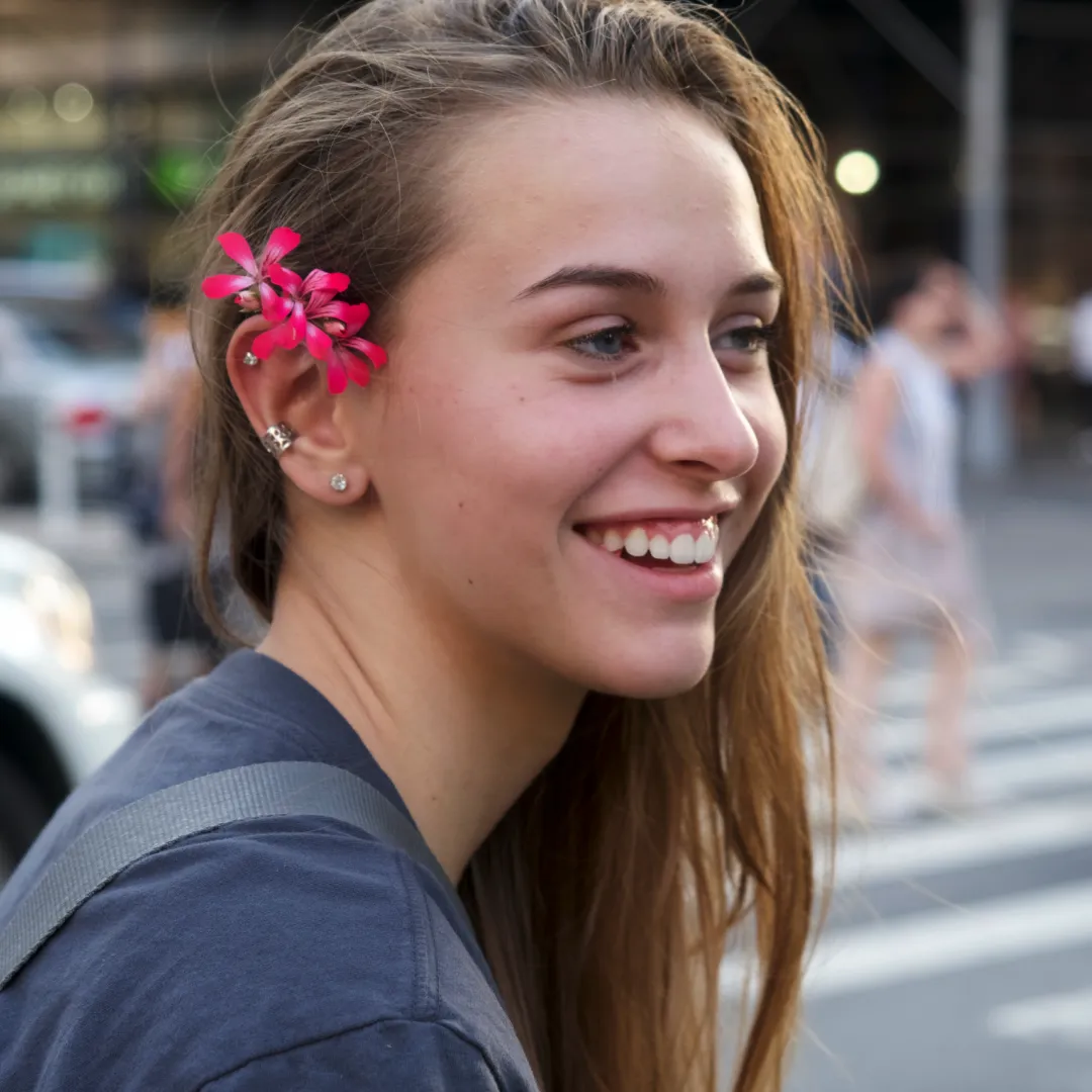 woman with a flower in her hair on a city street